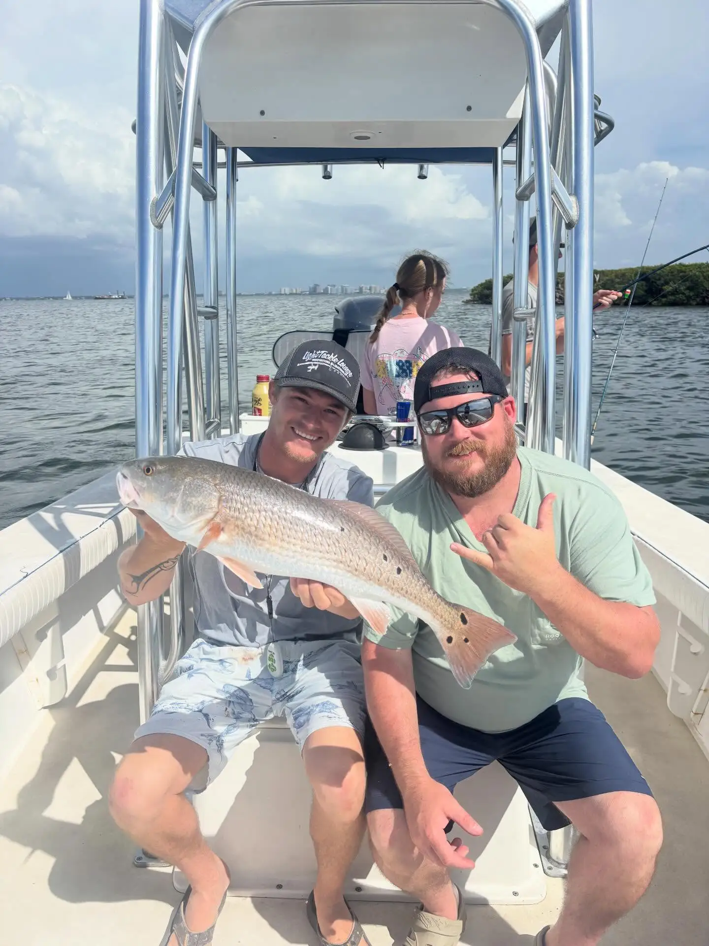Family anglers holding a redfish aboard a Sarasota family fishing charter.