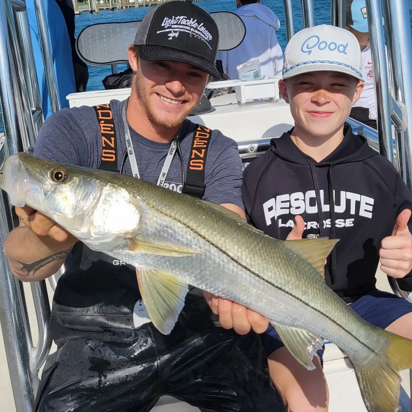 Young angler and captain holding a snook during a Sarasota family fishing charter in Sarasota, Florida.