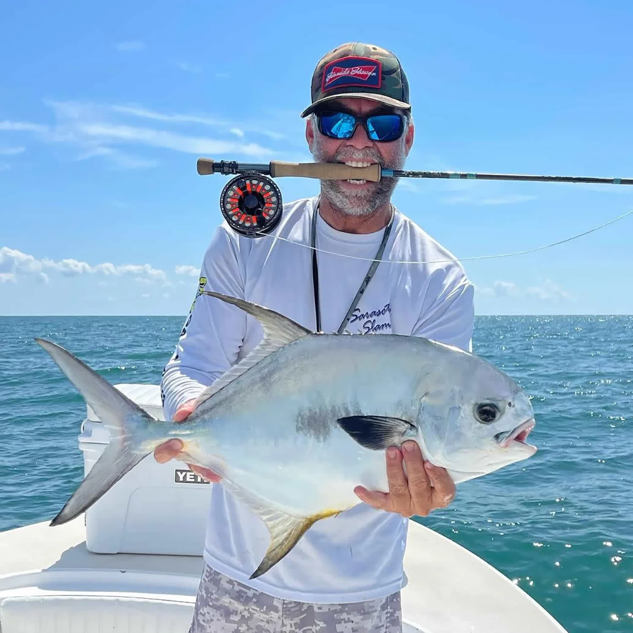 Angler holding a permit caught during a Sarasota fly fishing charter.