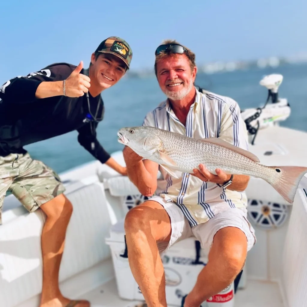 Happy anglers with a redfish caught during a Sarasota fly fishing charter.