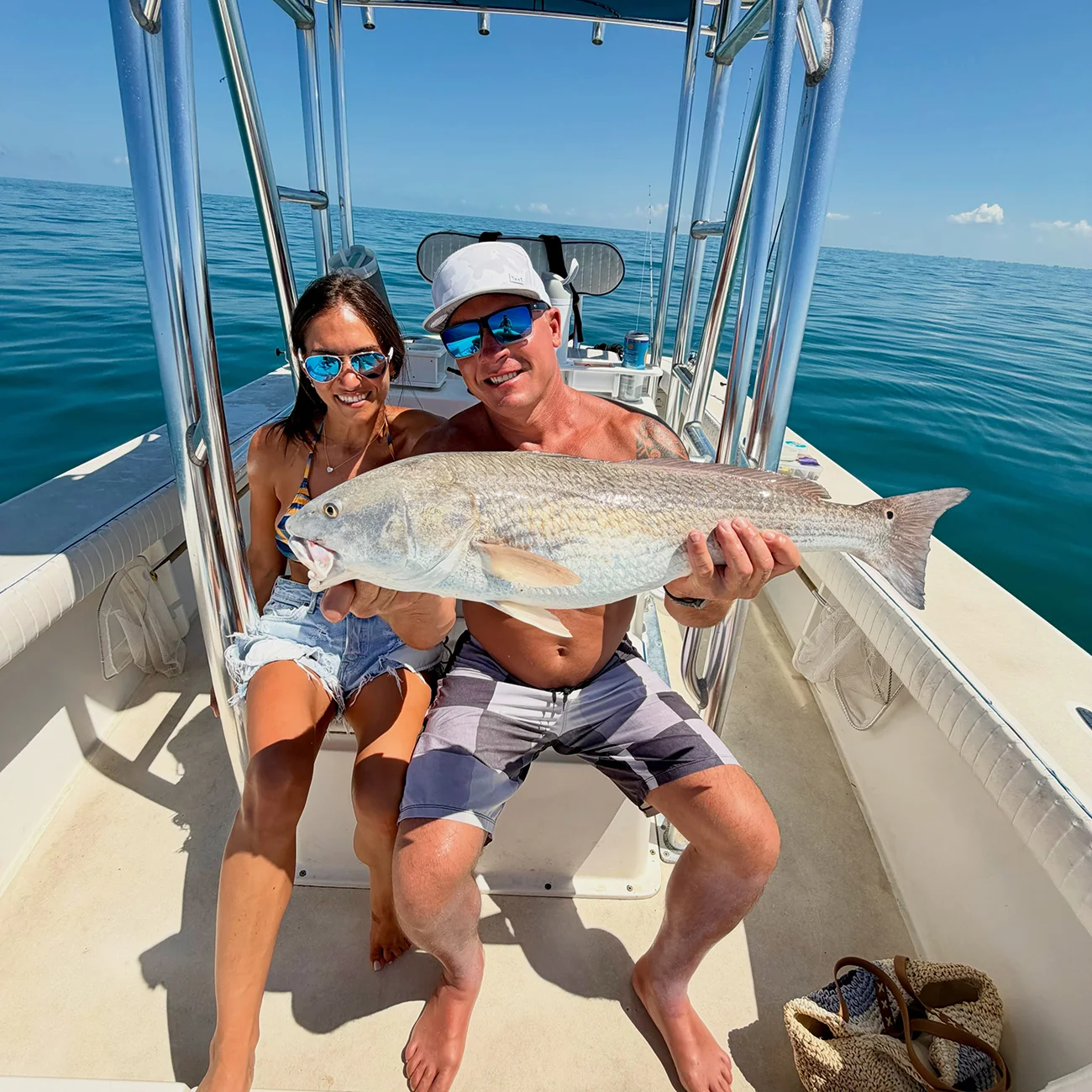 Couple holding a redfish during a Sarasota inshore fishing charter.