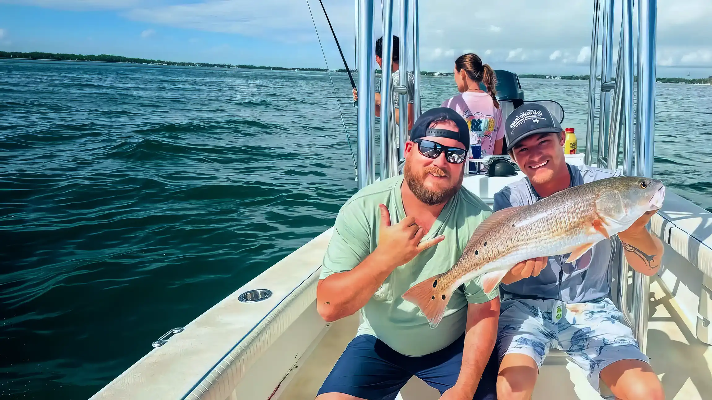 Anglers holding a redfish during a Sarasota inshore fishing charter.