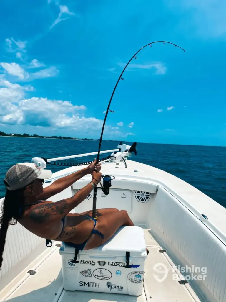 Woman fighting a powerful fish aboard a Sarasota fishing charter.