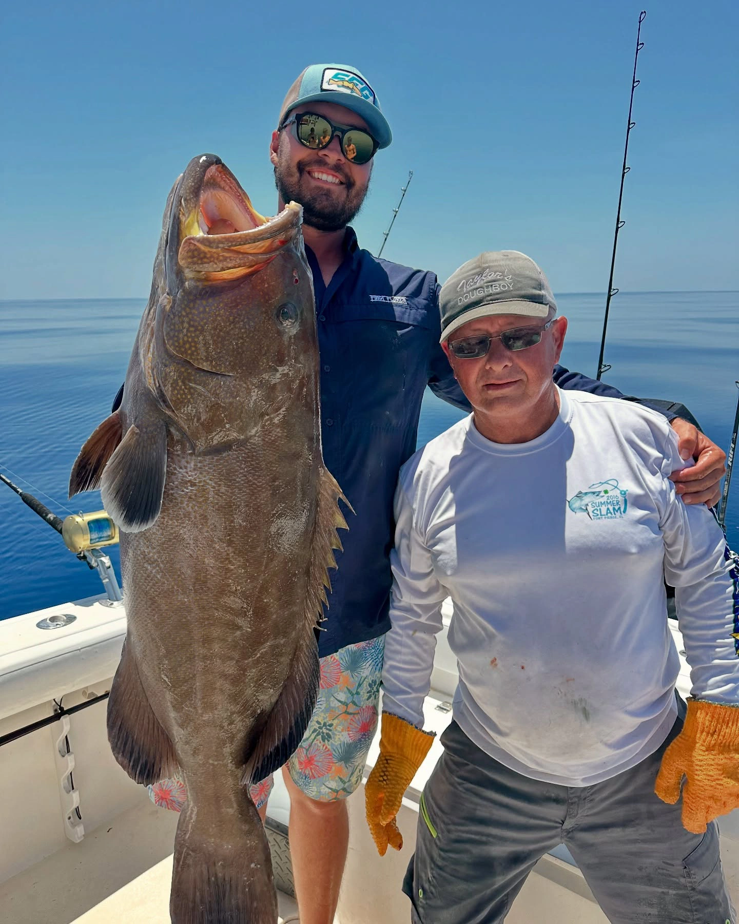 Captain and angler posing with a large gag grouper aboard a Sarasota fishing charter boat in the Gulf of Mexico.