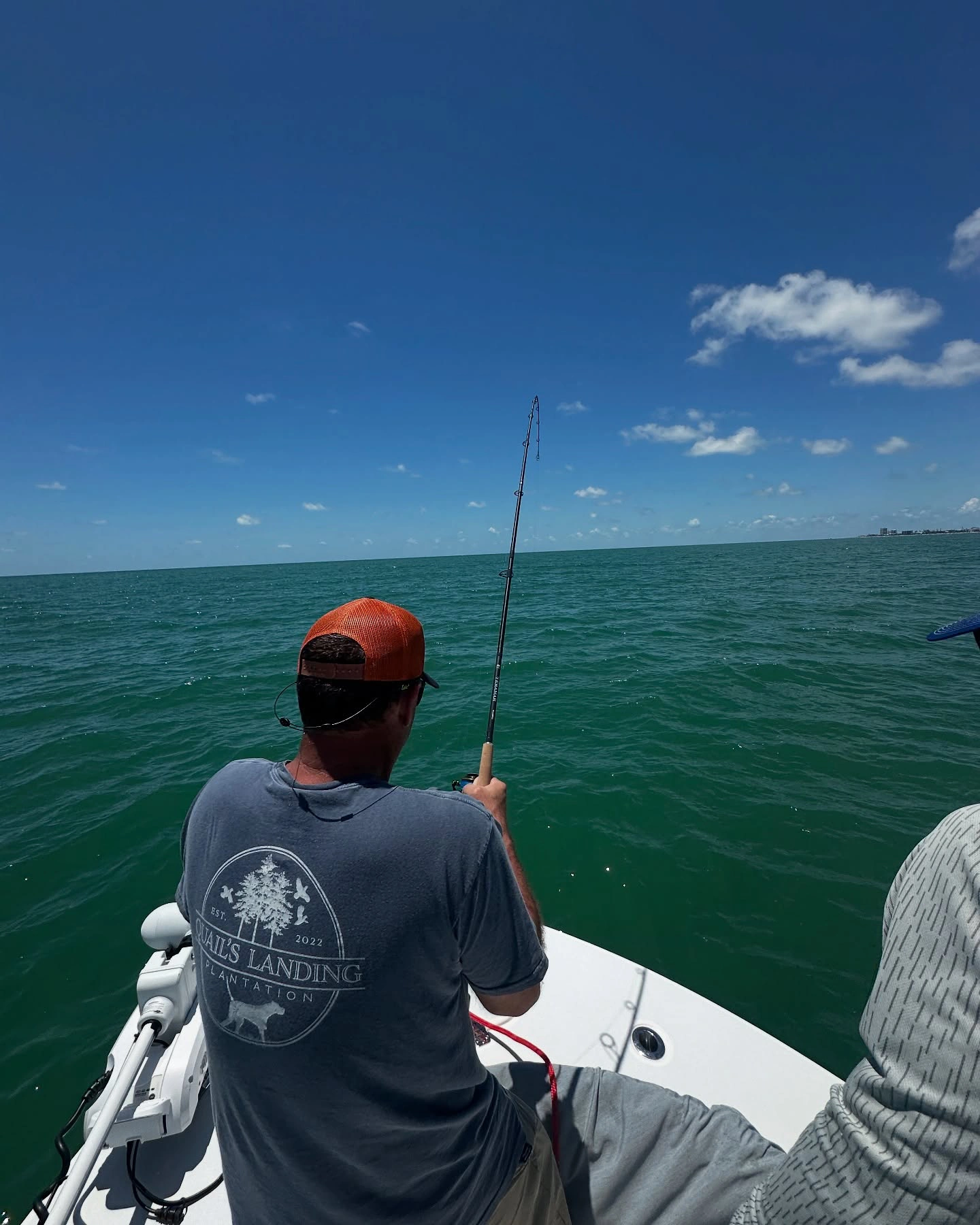 Angler battling a powerful fish from the bow of a Sarasota fishing charter boat in the Gulf of Mexico.