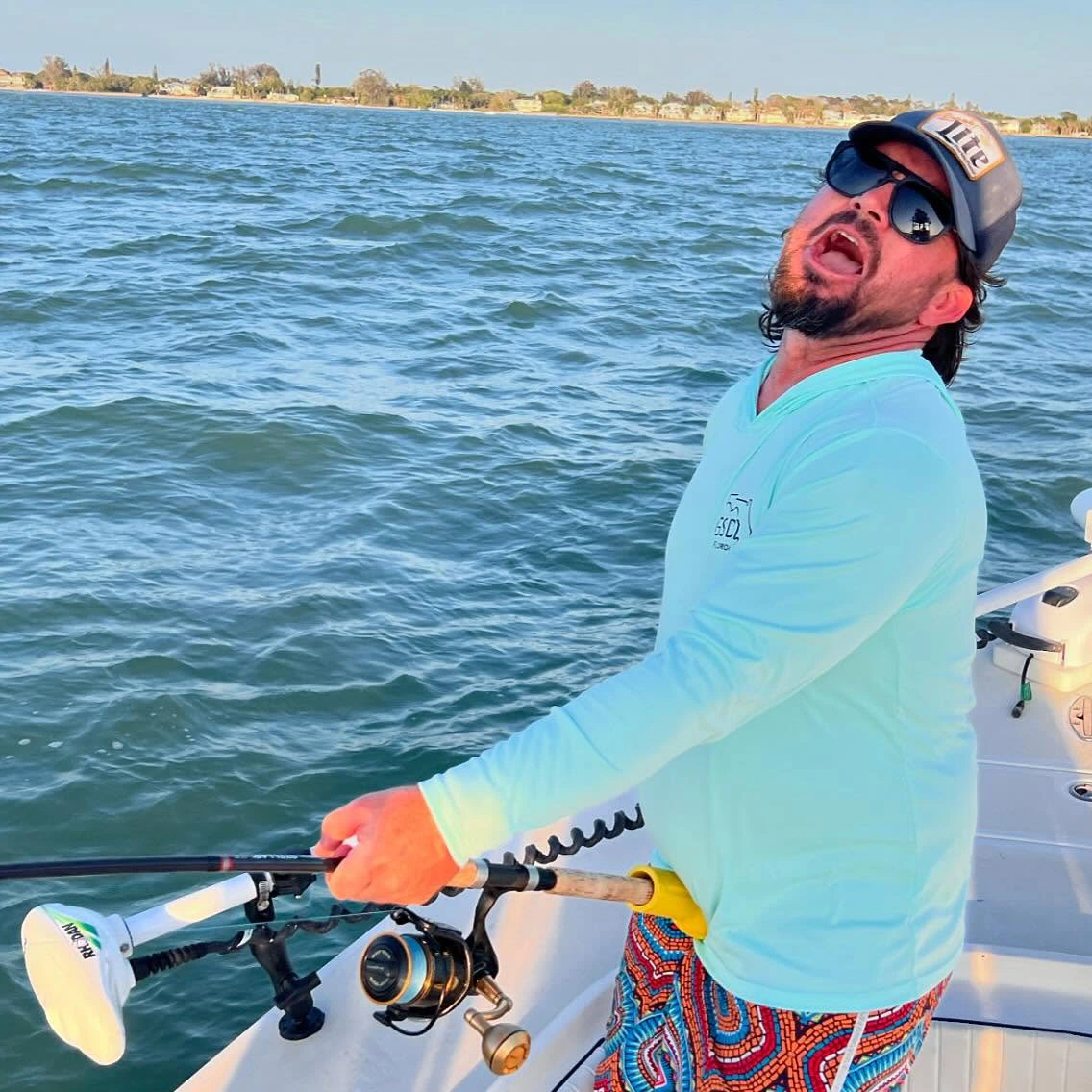 Angler fighting a powerful fish aboard a Sarasota custom fishing charter while enjoying a fun day on the water.