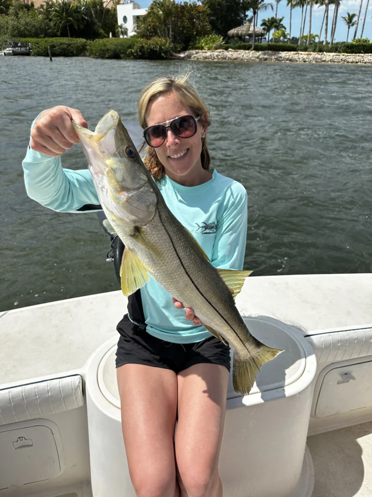 A woman holding a snook.