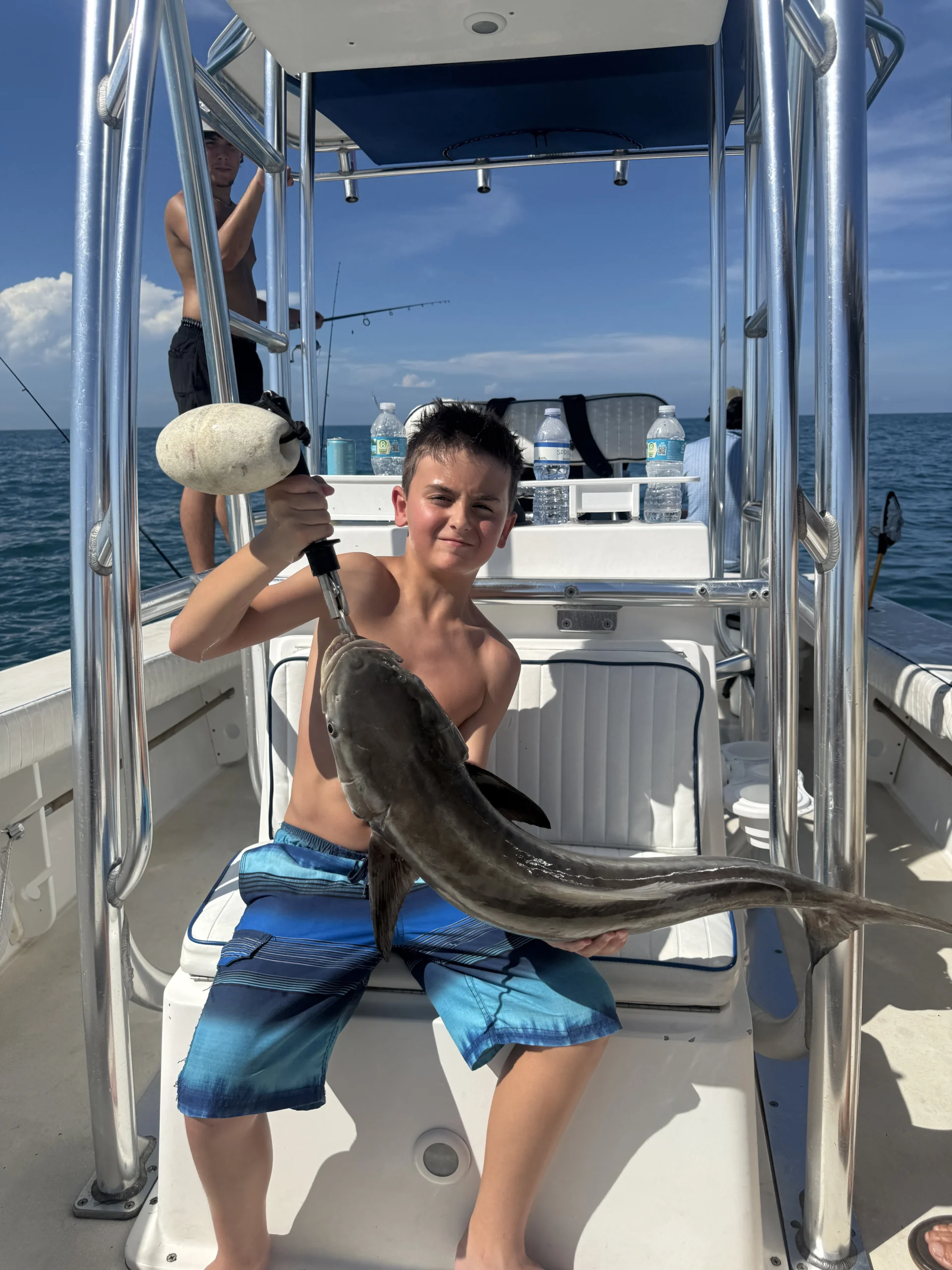 Young angler holding a gafftopsail catfish during a nearshore fishing trip in Sarasota, Florida.