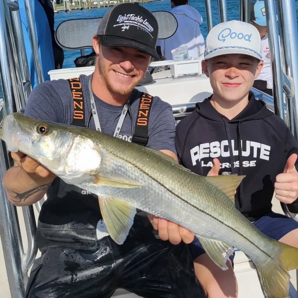 Young angler holding a trophy snook during a Sarasota spring break fishing charter.