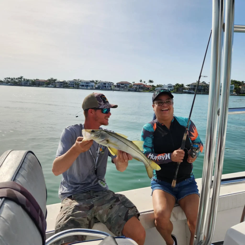 Young angler smiling with a snook during a Sarasota spring break fishing charter.