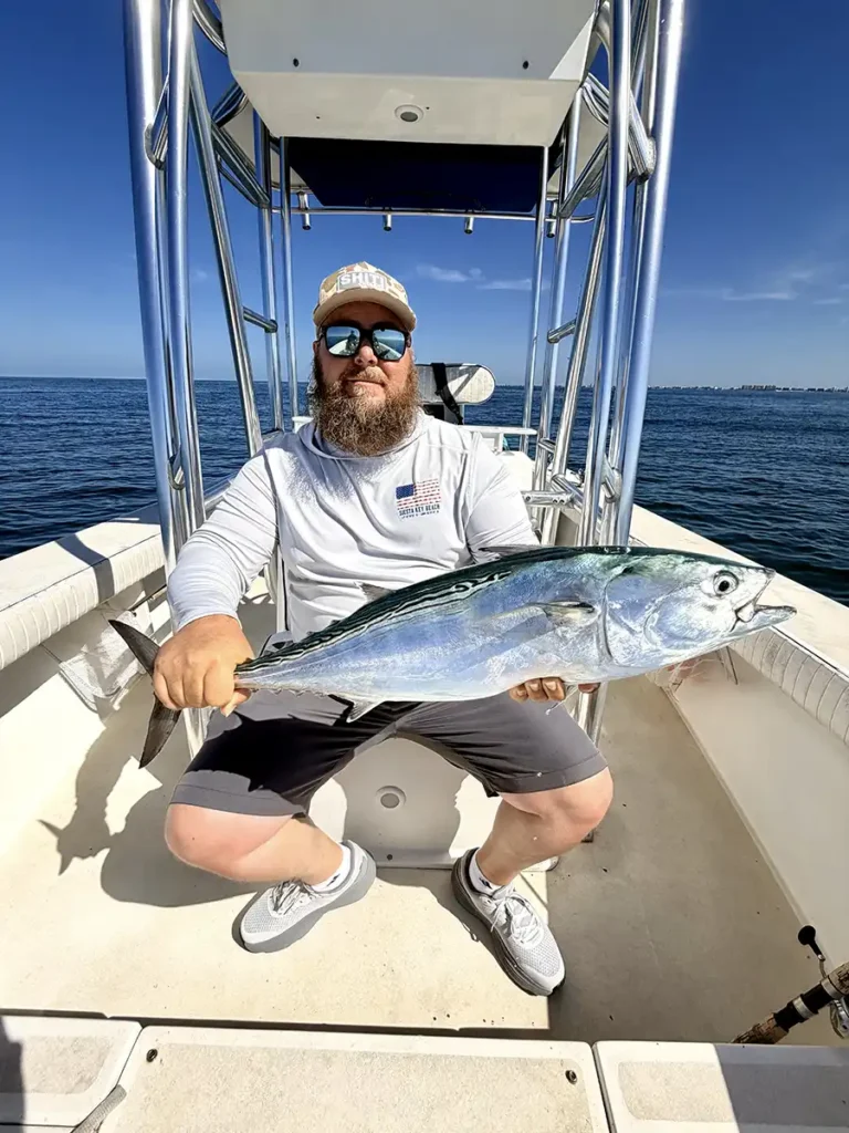 Angler holding a bonito aboard a fishing boat off Sarasota, Florida.